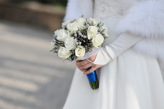 Bride holding white wedding bouquet.