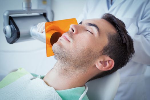 Close up of young man undergoing dental checkup in the dentists chair