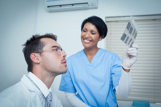 Smiling two dentists looking at x-ray