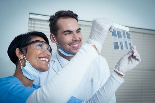 Smiling two dentists looking at x-ray