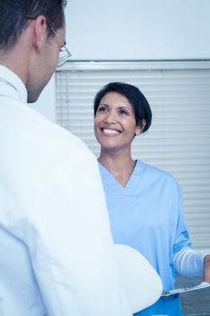 Male and female dentists discussing reports