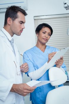 Male and female dentists discussing reports