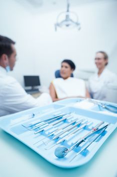 Male dentist and assistant with female patient in the dentists chair