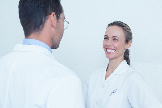 Smiling female and male dentists in discussion