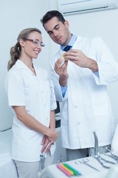 Male dentist and assistant looking at mouth model