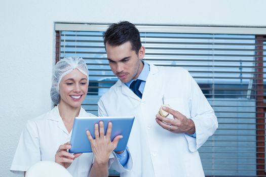 Male and female dentists using digital tablet