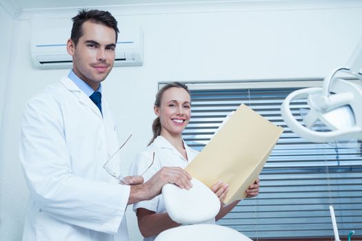 Portrait of male and female dentists with reports