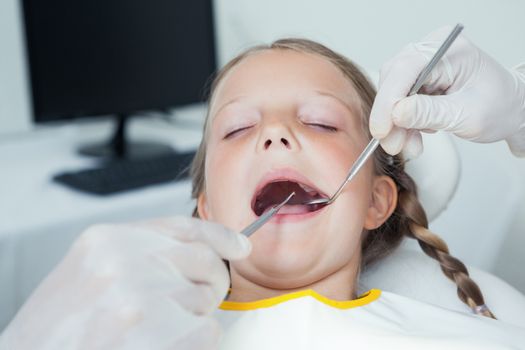 Close up of girl having her teeth examined by dentist