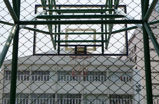 Orange basketball hoop on green stand in the race course.                               