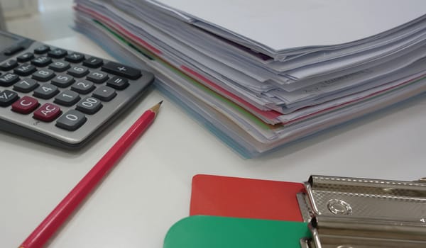 Pile of paperwork  and office supply placed on table in workplace.                                