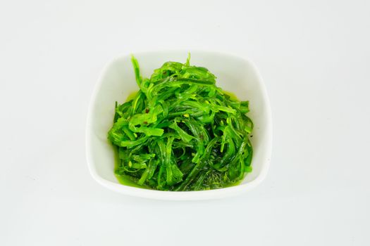 salad with seaweed with sauce and sesame seeds isolate on white background