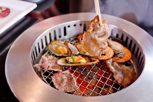 Mixed Roasted Meat and Seafood and Chopsticks on the BBQ Grill on roast.
