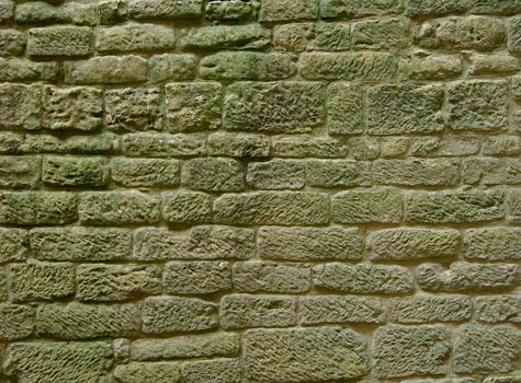 Background of Obsolete Rounded Stones with Moss-Covered Texture closeup