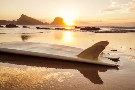 Silhouette of a surfboard at the beach with reflection 