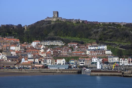 Scarborough Castle on a hillside above the town and harbor - North Yorkshire coast in the northeast of England.