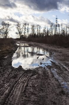 Mud and puddles on the dirt road.