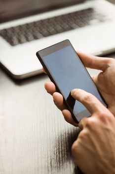 Student touching his mobile phone in cafe at the university