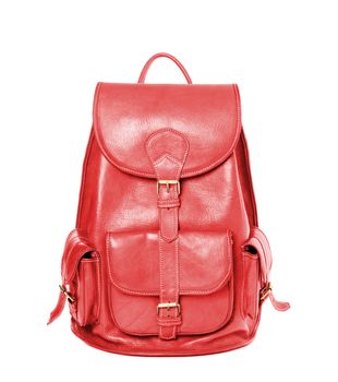 Red leather backpack standing isolated on white background