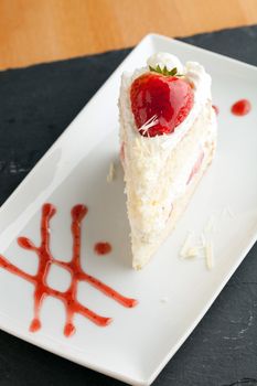 Slice of strawberry shortcake with white chocolate shavings.