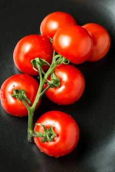 Bunch of tomatoes on black plate