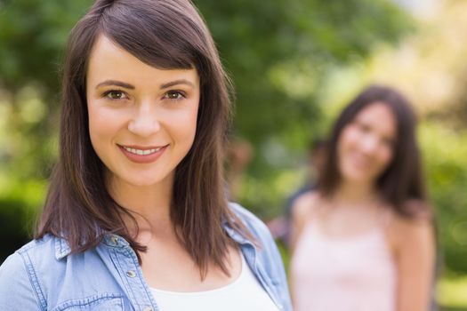 Pretty student smiling at camera outside on campus at the university