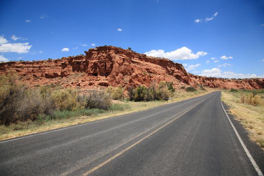 Road heads towards the mountains and buttes in Southwestern United States