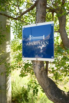 Free apartment room sign outdoors on a tree