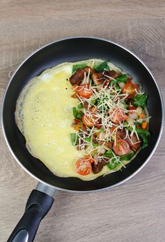Omelette with vegetables and cheese in a pan