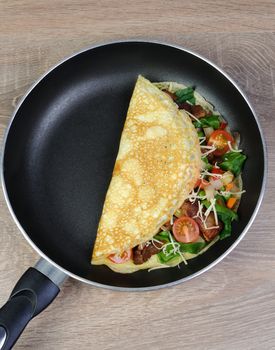 Omelette with vegetables and cheese in a pan