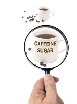 magnifying glass of roasted coffee beans and coffee cup,see a 
caffeine and sugar concept
