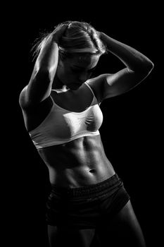 Black and white image of a muscular female against black background.