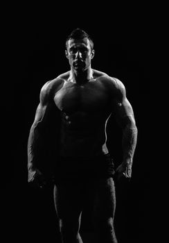 very muscular handsome athletic man on black background, naked torso, black-and-white