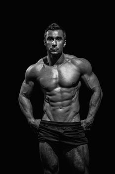 very muscular handsome athletic man on black background, naked torso, black-and-white