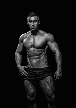 very muscular handsome athletic man on black background, naked torso, black-and-white