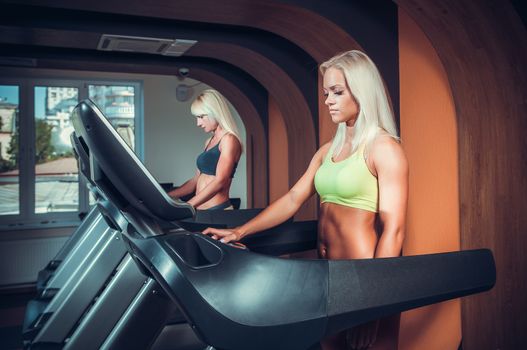 young people running on treadmill in gym 