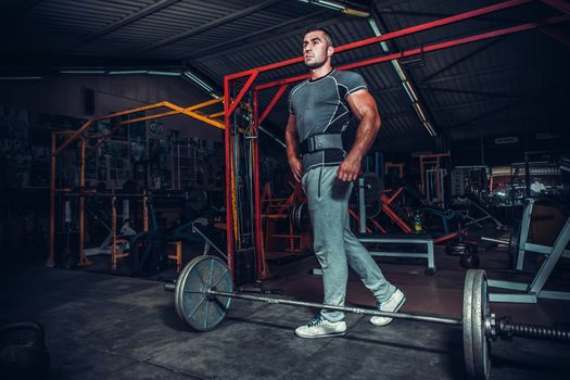 Bodybuilder preparing for deadlift of barbell 