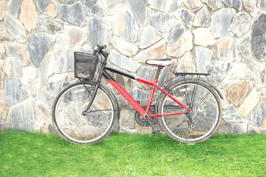 old red bicycle leaning against a wall
