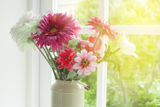 Flowers in glass vase near the window