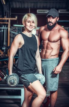 Couple of well trained bodybuilder with dumbbells