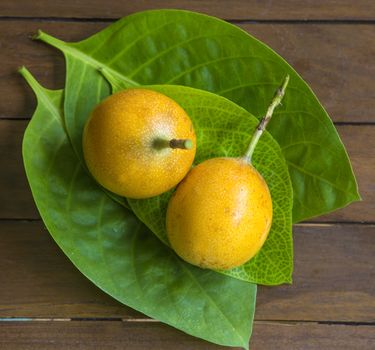 Passion fruits and Green Leaf on Wooden Background