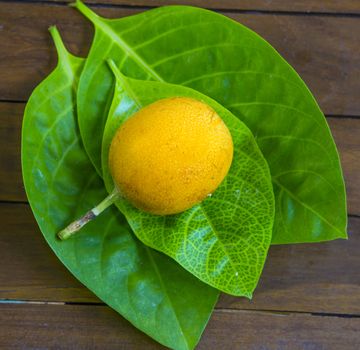 Passion fruits and Green Leaf on Wooden Background