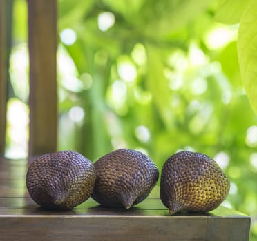 Snake Fruit and Green Leaf on the Wood Table.