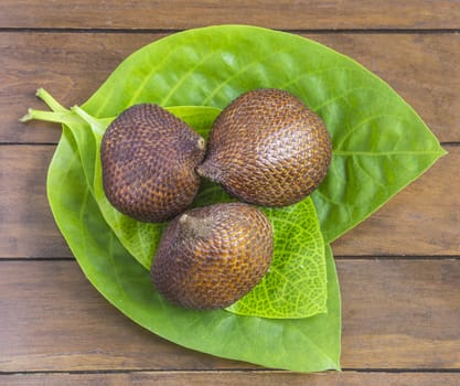 Snake Fruit and Green Leaf on the Wood Table.