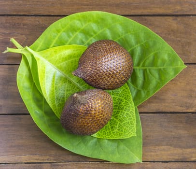 Snake Fruit and Green Leaf on the Wood Table.