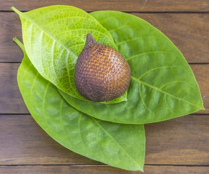 Snake Fruit and Green Leaf on the Wood Table.