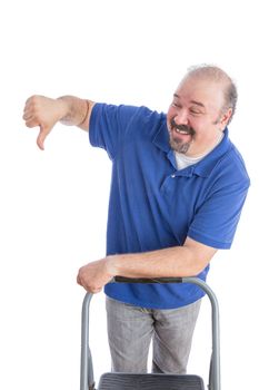 Happy Adult Bearded Man in Blue Polo Shirt, Leaning Against a Chair While Showing Thumbs Down Sign to Someone. Isolated on White.