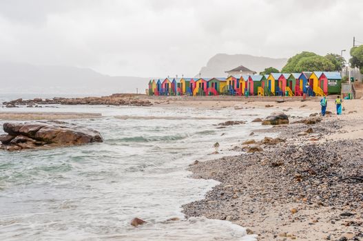 CAPE TOWN, SOUTH AFRICA - DECEMBER 12, 2014:  Multi-coloured beach huts at St. James beach on a rainy morning