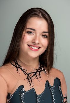 portrait of a smiling young gymnasts closeup on a gray background