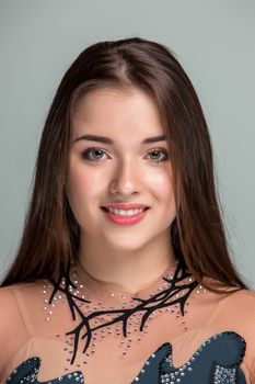 portrait of a smiling young gymnasts closeup on a gray background