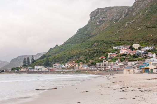 CAPE TOWN, SOUTH AFRICA - DECEMBER 12, 2014:  Unidentified surfers at Muizenberg beach on a gloomy and rainy daybreak